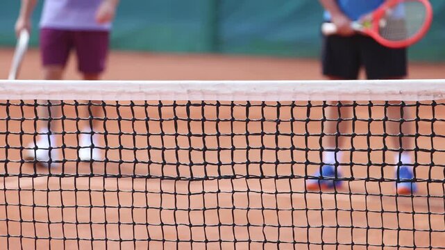 Tennis tournament championship on outdoor clay court with net, professional athletes play in motion with rackets serve tennis ball during tennis match game, tennis training in a sunny day on a stadium