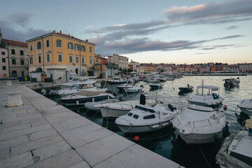 A view of the old town and colorful buildings of Rovinj, as well as the marina with moored boats, shortly after sunset. A popular resort on the Croatian Istria peninsula.