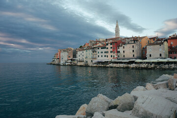 A view of the old town and colorful townhouses of Rovinj, with the distinctive tower of St. Euphemia's Church, shortly after sunset. A popular resort on the Croatian Istria peninsula.