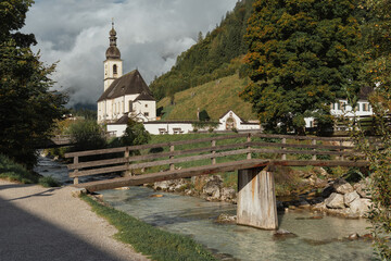 Ramsau am Berchtesgaden, Germany. Autumn landscape of Saint Sebastian Church and River Ramsauer Ache, Bayern.