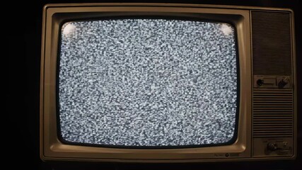 Retro TV Static Noise - A vintage television displays white analog static noise on its screen. The video captures the retro aesthetic of a classic CRT television set.