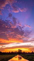 Vibrant twilight sky reflects on a tranquil waterway, golden hues