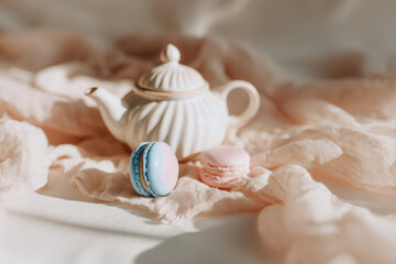 Ceramic teapot pastel macaron linen napkin soft sunlight elegant flat lay spring mood cozy delicate dessert sweet treat create gentle and inviting atmosphere