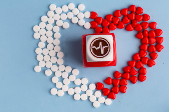 Heart-shaped pills and hearts and a medicine cube. The concept of medicine and treatment