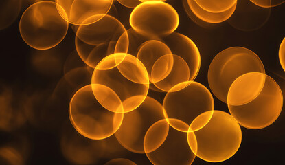 Abstract glowing orange bokeh circles creating a warm and magical festive light background effect