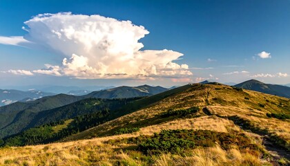 A panoramic view of rolling hills and mountain ranges under a dramatic cloud formation in a sunny, clear blue sky