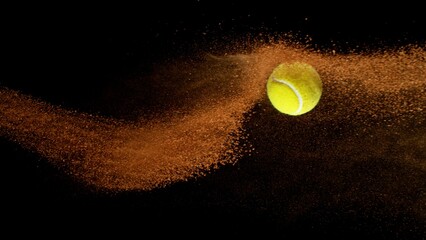 Freeze Motion Shot of Flying Tennis Ball with Clay , Isolated on Black Background
