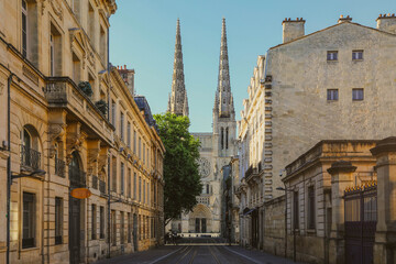 Fototapeta premium City street scene with tram rails and Saint Andre Cathedral in Bordeaux, France