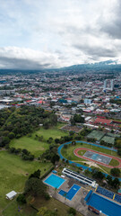 Obraz premium Vertical shot of an aerial view of a park with trees and a city in the capital of San Jose, Costa Rica.