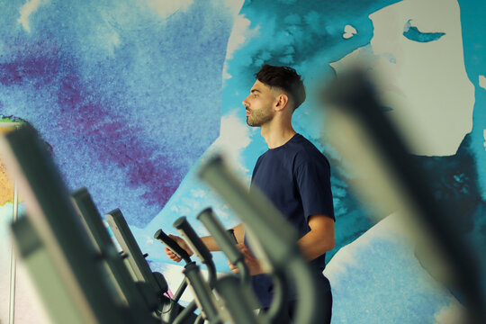 Man on an Elliptical Bike in a Gym