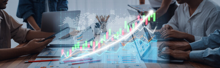 Obraz premium A dynamic business team engages in collaboration and financial planning, utilizing technology and visual data to drive informed decision-making in a modern office environment. Axiom