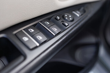 Obraz premium Car interior door panel with control buttons for windows and mirrors
