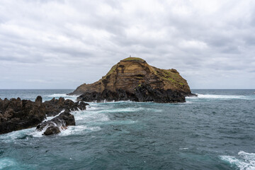 Fototapeta premium Waves crashing against black rocks in Porto Moniz in Madeira, Portugal