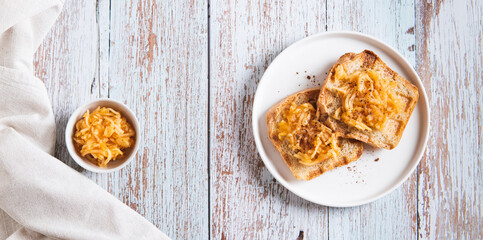 Sweet apple jam on croutons on a plate on the table top view web banner