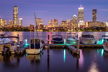 The skyline of Boston in Massachusetts at night as seen from Memorial Driver Road in Cambridge, MA, USA with the famous Charles river in between the two cities.