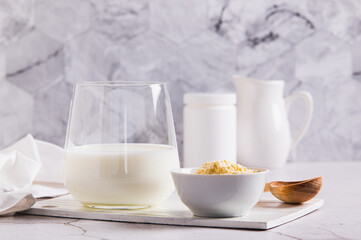 Colostrum powder in a bowl and a drink in a glass on a table