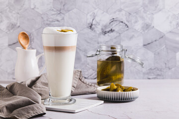 Latte with pickles in a glass and pickles in a bowl on the table