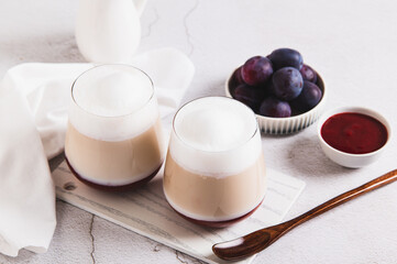 Coffee latte with berry syrup in glasses on the table