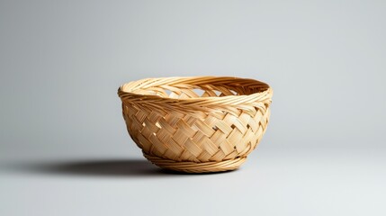 Photograph of a small woven basket. the basket is made of light-colored wood and has a woven texture. it has a round shape with a flat base and a narrow opening at the top.