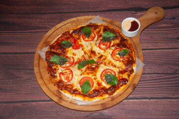 Delicious Italian Beef Pizza with Mozzarella Cheese, Tomato and Fresh Basil on wooden board top view of Perfect for menus