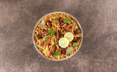 Spiced chicken masala biryani on brown background. Top view. Indian food.