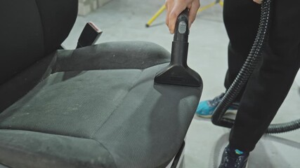Skilled cleaner rejuvenates worn-out car seat using vacuum cleaner. Experience the satisfaction of seeing dirt vanish and freshness return. 4K, UHD