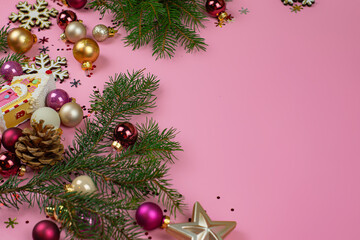 Christmas composition made with green Christmas tree and pink Xmas baubles on pastel pink background. Minimal Christmas and New Year concept. Creative festive holiday layout.