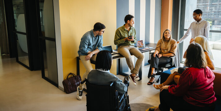 Diverse group of people having a meeting in a modern office workspace - Powered by Adobe