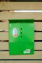 battery recycling box for sustainability and waste management. green box promotes eco-friendly disposal of used batteries and electronics in urban settings. emphasizes recycling awareness