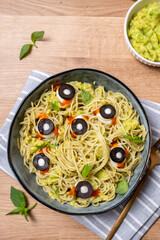 A bowl of pasta with olives and sauce