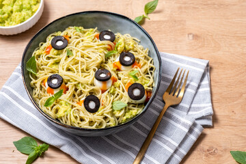 A bowl of pasta with olives and sauce