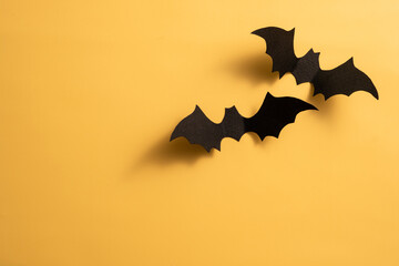 Four black bats are hanging from the ceiling