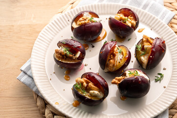 A plate of fruit with nuts and herbs on top