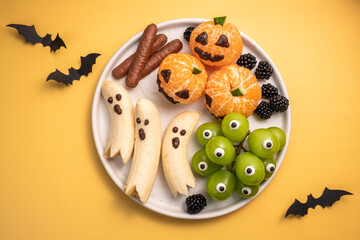 A plate of Halloween themed fruit and vegetables