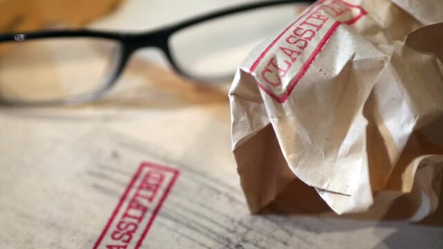 An old  sensitive documents and secret information with the stamp CLASSIFIED dolly shot