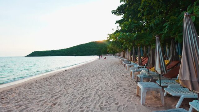 Empty beach chair on white sand beach windy sunset sky summer vacation background