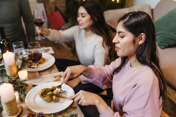 Latin friends having christmas dinner at home in Mexico Latin America, group of hispanic young people eating in Holidays and thanksgiving