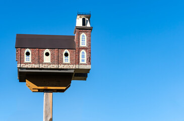 Close-up of a Very Elaborate Birdhouse Modelled After a Church Against the Blue Sky