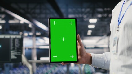 Close up of data center employee doing maintenance tasks on isolated screen tablet, ensuring optimal performance. Worker using chroma key device to review diagnostics and apply patches