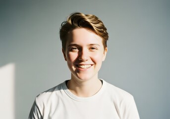 Smiling Person in White T-Shirt Against Neutral Wall — Natural Portrait with Sunlight and Soft Shadows