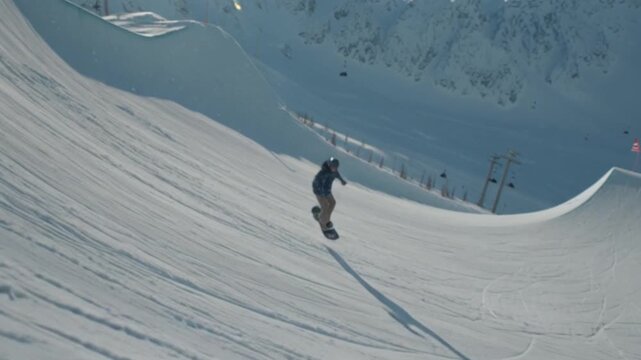 A professional snowboarder performs a daring stunt on a half pipe, captured in a cinematic shot that highlights dynamic motion, skill, adrenaline, and the thrill of winter extreme sports