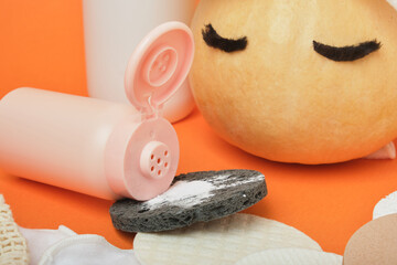 Enzyme powder for autumn skin care, pumpkin and various sponges for removing makeup and washing on an orange background, reusable pads