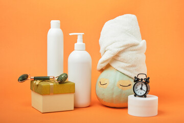 Pumpkin, gift boxes and various cosmetics on an orange background, holiday gift-giving and sales concept, autumn self-care