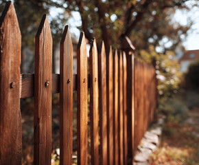 Weathered wooden fence with autumn background

