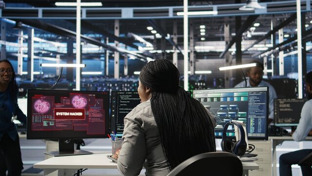 Server farm engineering team collaborating to protect against data theft during cyberattack. Data center coworkers rushing to safeguard infrastructure systems during security breach, camera A - Powered by Adobe