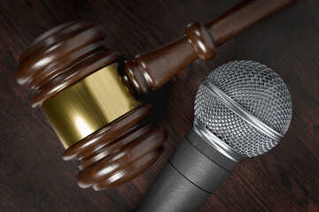 Close-up of a Gavel and Microphone Resting on a Wooden Table.