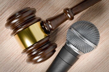 Close-up of a Gavel and Microphone Resting on a Wooden Table.