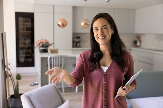Fototapeta Cheerful Hispanic real estate professional showing air space for object