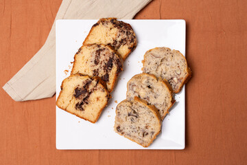 Top view of a plate with pieces of banana bread and chocolate bread.