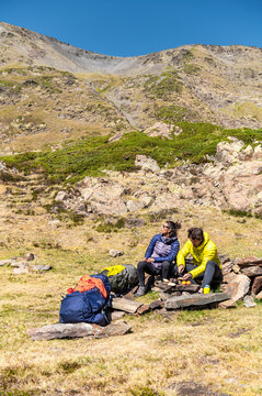 Relaxed hikers enjoying sunny rest in mountain valley